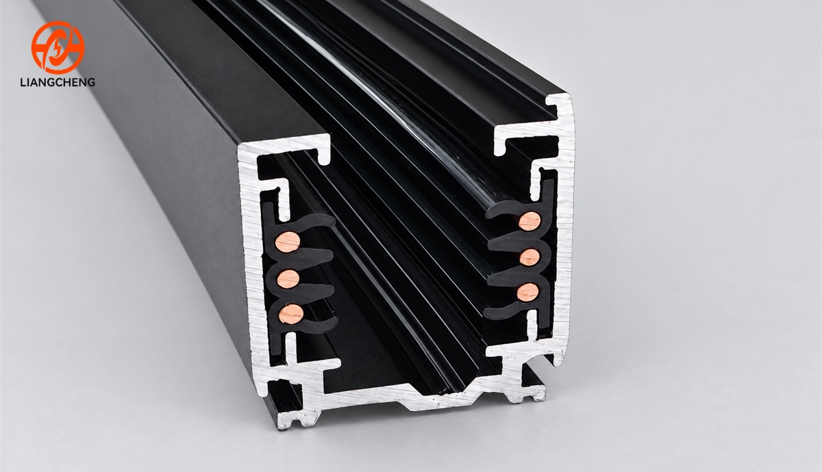 Six copper conductor contacts arranged three per side inside a black track rail